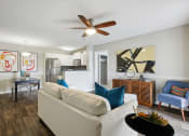 Thumbnail 3 of 13 - a living room with a couch and a ceiling fan