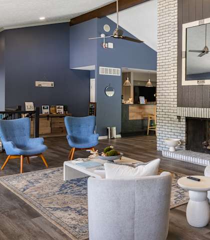 A living room with a fireplace and a large mirror above it.