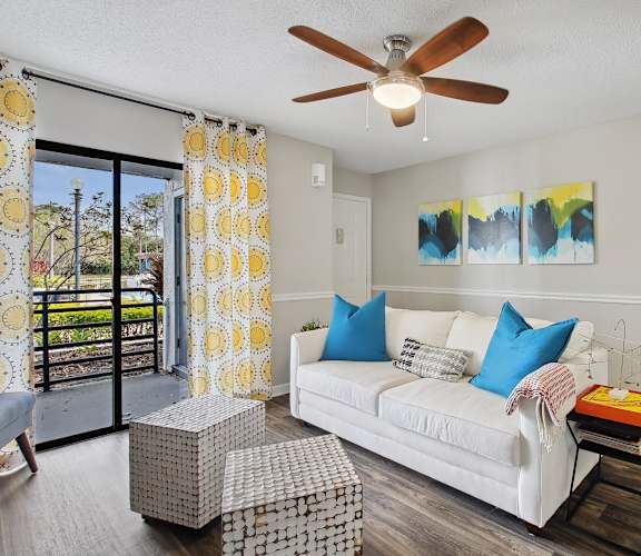 a living room with a white couch and a ceiling fan
