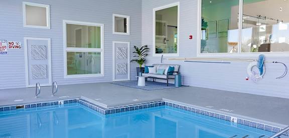 A pool with a bench and a glass door.