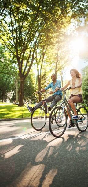 a man and a woman riding bikes down a street