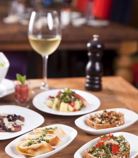 a table filled with plates of food and a glass of wine at Residences at Manchester Place, Manchester