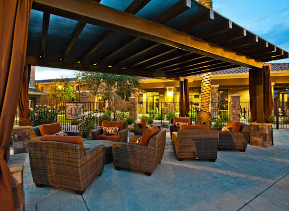 a patio with couches and chairs outside of a resort