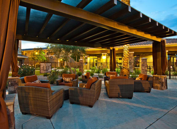 a patio with couches and chairs outside of a resort