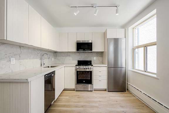 A kitchen with white cabinets and a marble countertop.at 111 Cosburn, East York, ON M4J 2L1