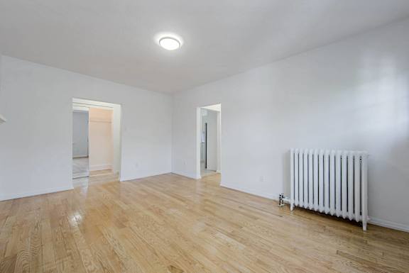 A room with wooden floors and a white radiator.at 83-85 Silver Birch, Toronto