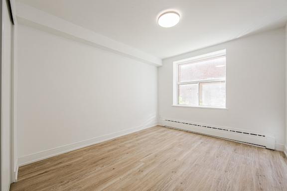 A room with a window and a radiator on the wall.at 111 Cosburn, Ontario, M4J 2L1