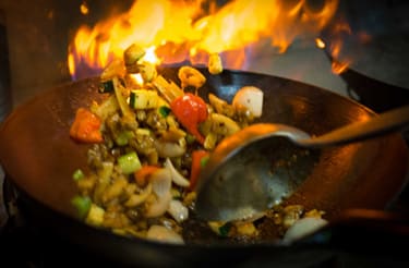 a wok filled with food cooking on a fire at Chandler Heights, Chandler, AZ