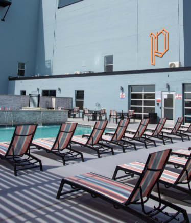 a row of deck chairs next to a pool