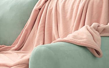 a green couch with a pink blanket on it