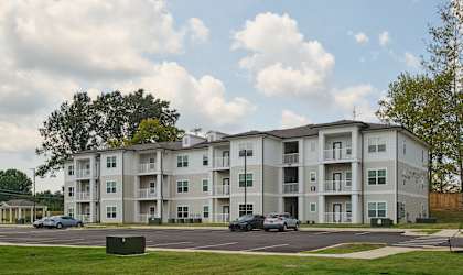 Apartment building with cars parked in front.