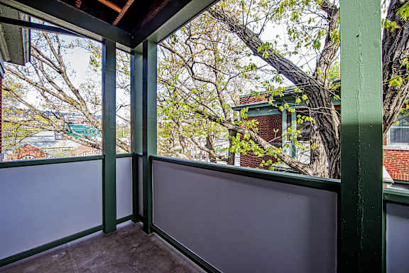 A balcony with a view of a tree and a building.at 83-85 Silver Birch, California