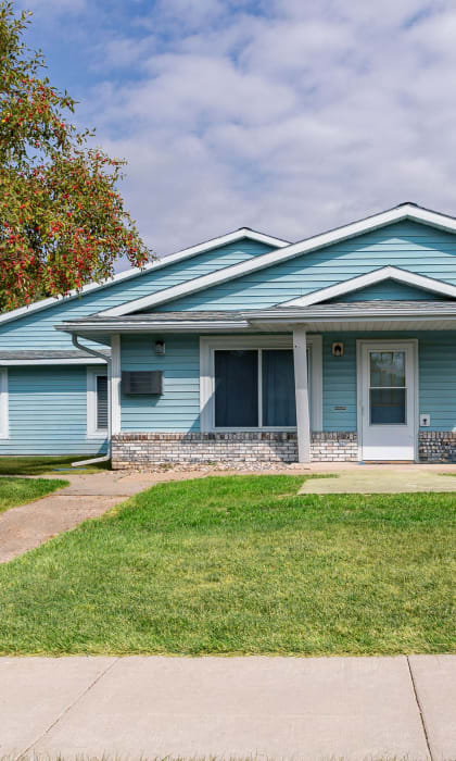 a blue house with a tree in front of it