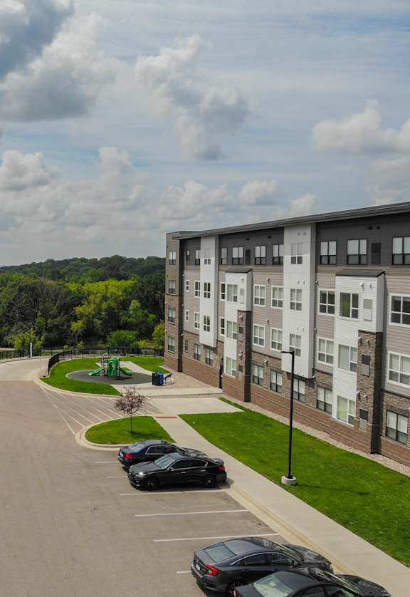 an aerial view of a parking lot with cars and buildings