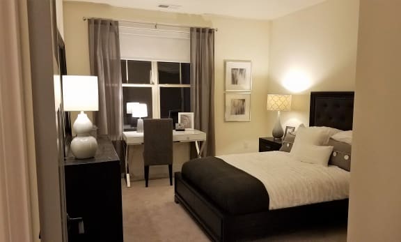 a bedroom with a bed and a desk and a window
