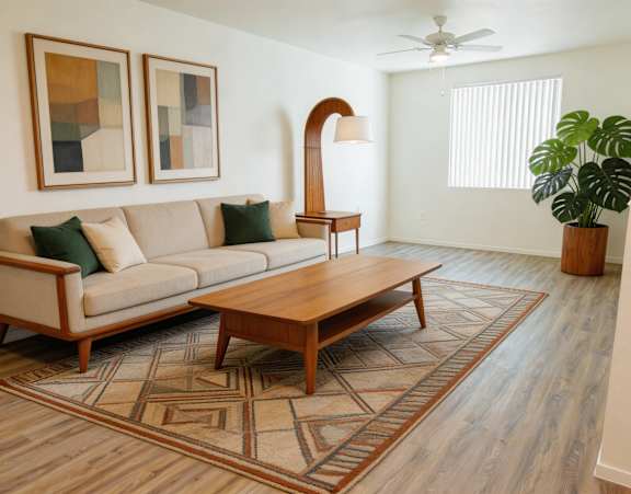 A living room with a couch, coffee table, and a plant.