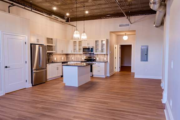 A kitchen with wooden floors and white walls.