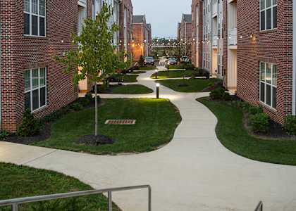 a view of an apartment complex with a walkway and sidewalk
