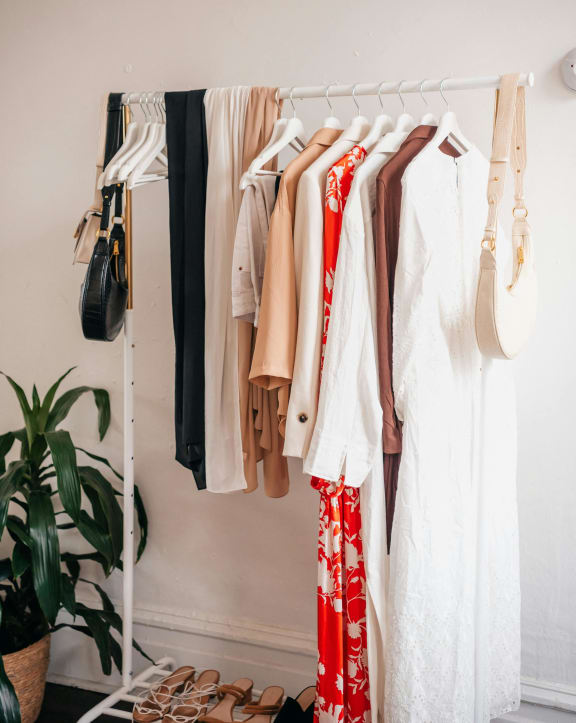 a wardrobe of clothes hanging on a rack in a room