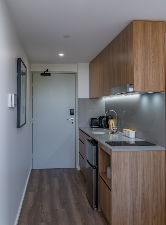 a small kitchen with wooden cabinets and a white door