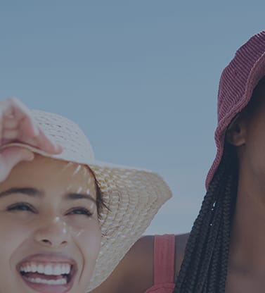 two women wearing hats and laughing on the beach at Element, Tampa, 33602