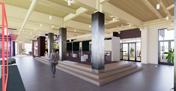 A man is walking through a large, open space with a series of columns. at University Commons in Pittsburgh, PA
