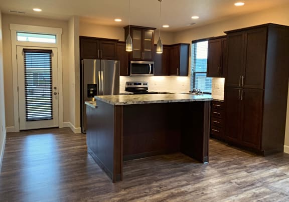 a kitchen with a center island and a stainless steel refrigerator