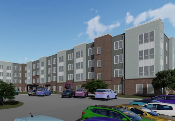 A parking lot with cars and a bus in front of apartment buildings.