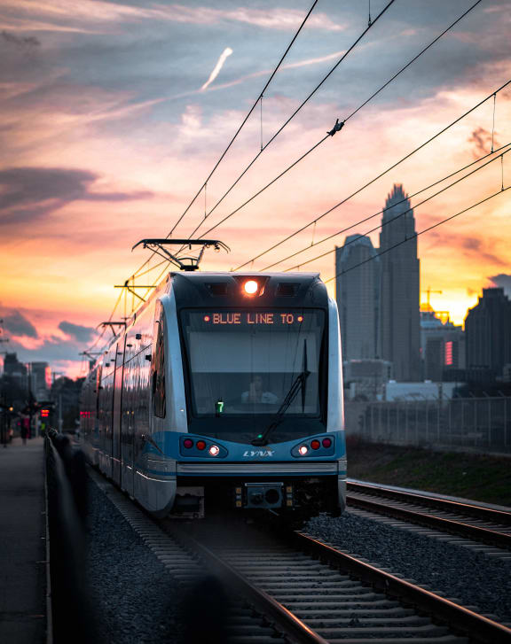 a blue line train on the tracks at sunset