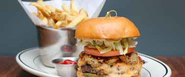A burger with fries and ketchup on a plate.