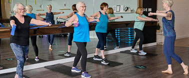 A group of women are exercising in a gym.