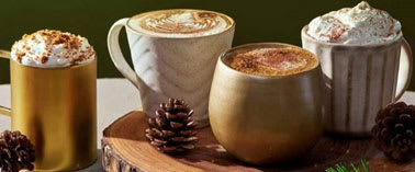 Four different types of coffee are served in mugs and a cup.