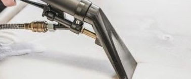 A close-up of a spray gun with a hose attached.