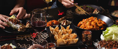 A group of people enjoying a variety of dishes at a table.