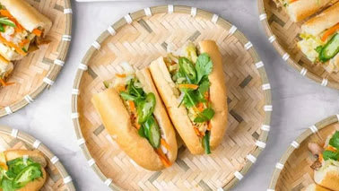 A bamboo tray holds a sandwich with lettuce and other fillings.