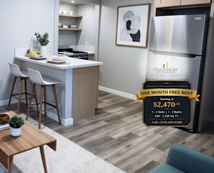 A living room with a couch, a table, and a kitchen area with a fridge and a sign that says "ONE MONTH FREE RENT $2,470".