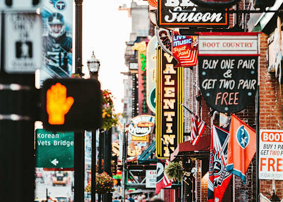 A busy street with a Whiskey Bar and a Buy One Get Two Free offer.