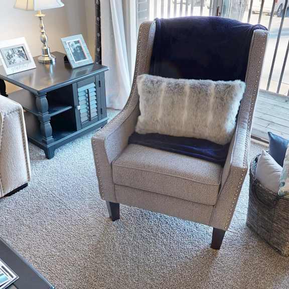 A living room with a chair, a sofa, a coffee table, and a basket.