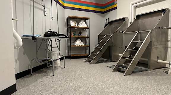 A room with a metal staircase and a table with a white container on it.