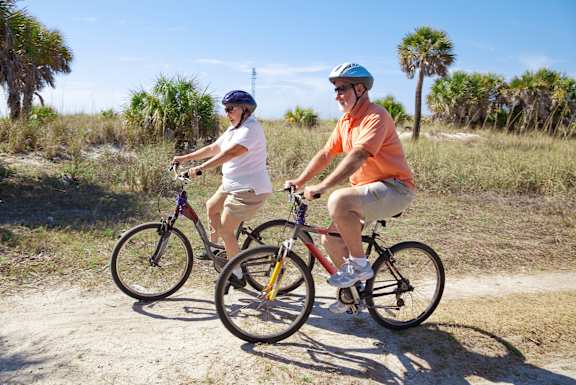Two people riding bikes on a dirt path.