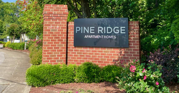 a brick wall with a sign that reads pine ridge apartments