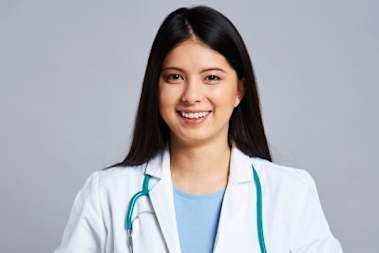 A woman in a white lab coat with a stethoscope around her neck.