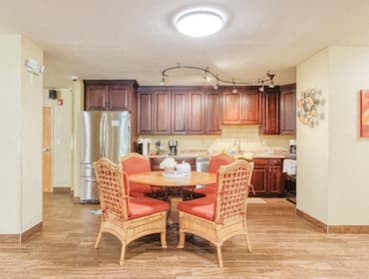 community kitchen with dining table, track lighting, and ample cabinetry