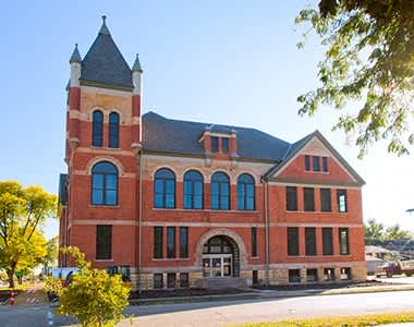 a large brick building with a tower and a street in front of it