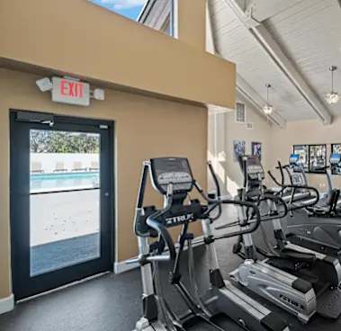 A gym with treadmills and an exit sign.