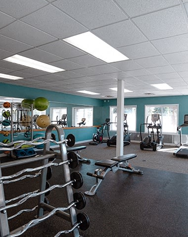 a gym with weights and other equipment in a room