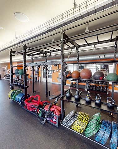 a gym with a rack of weights and other equipment