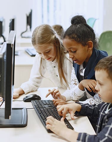 a group of children working on a computer