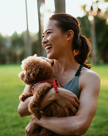 a woman holding a teddy bear in a park