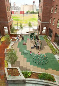 A playground area with a green net ball in the middle.